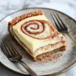 Irresistible Cinnamon Roll Cheesecake Recipe: A Sweet Dessert Delight 9 Slice of Cinnamon Roll Cheesecake with glaze drizzle