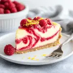 Irresistible Lemon Raspberry Swirl Cheesecake Recipe for Dessert Lovers 9 Slice of Lemon Raspberry Swirl Cheesecake with raspberry and lemon zest