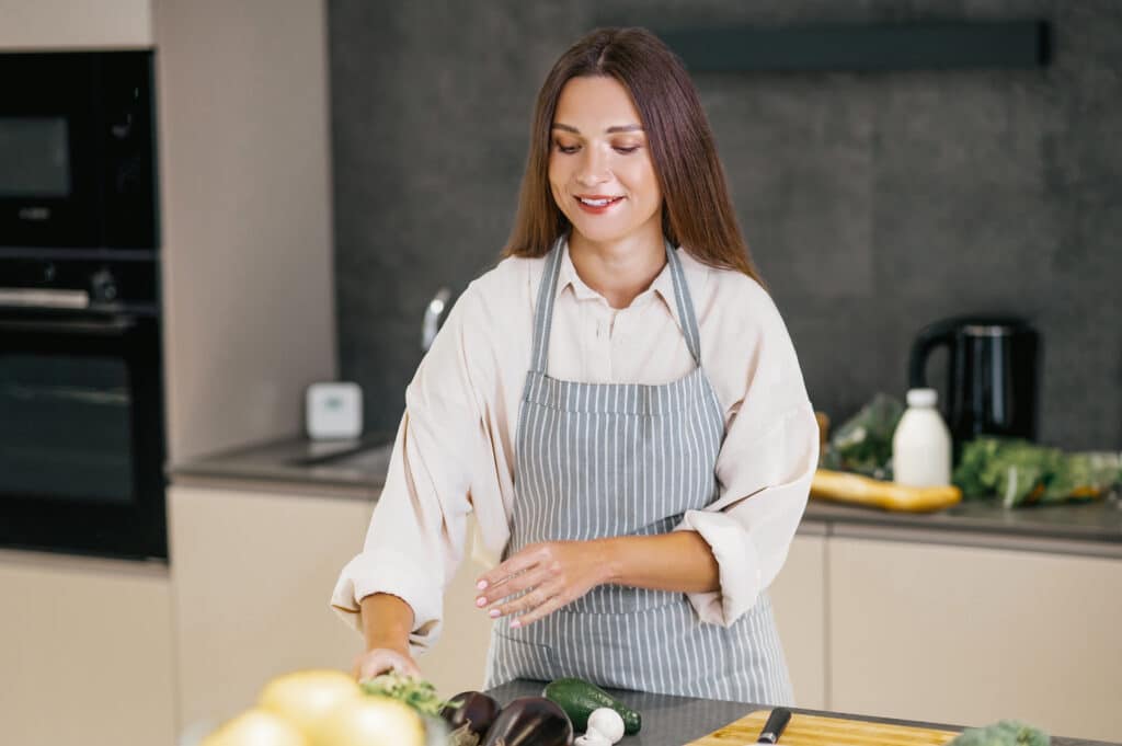 About Us 1 Young woman cooking in a cozy kitchen with love and focus