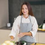 Young woman cooking in a cozy kitchen with love and focus