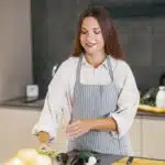Young woman cooking in a cozy kitchen with love and focus