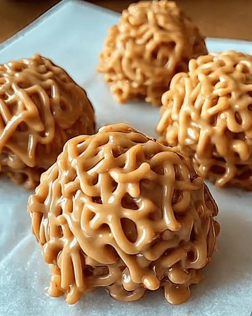 Peanut Butter Haystacks stacked on wooden board with glossy finish